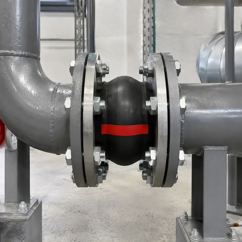 Junta de expansión EPDM bridada instalada en tubería industrial para absorber vibraciones, movimientos y dilataciones.